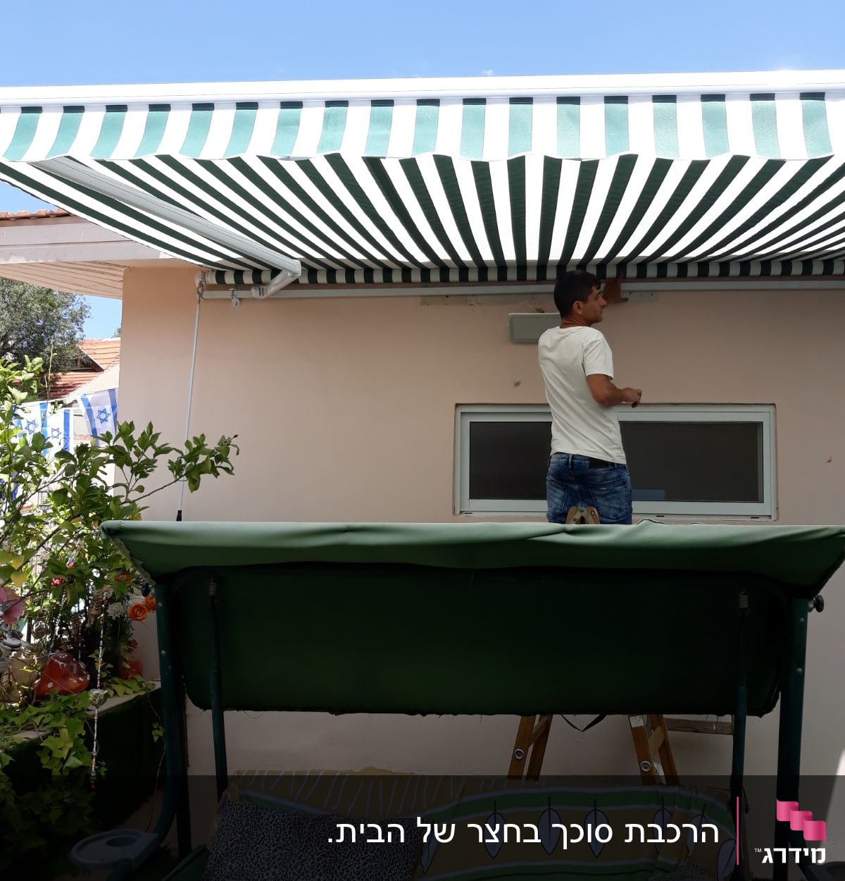 סוכך פסים ירוק לבן מותקן על קיר חיצוני